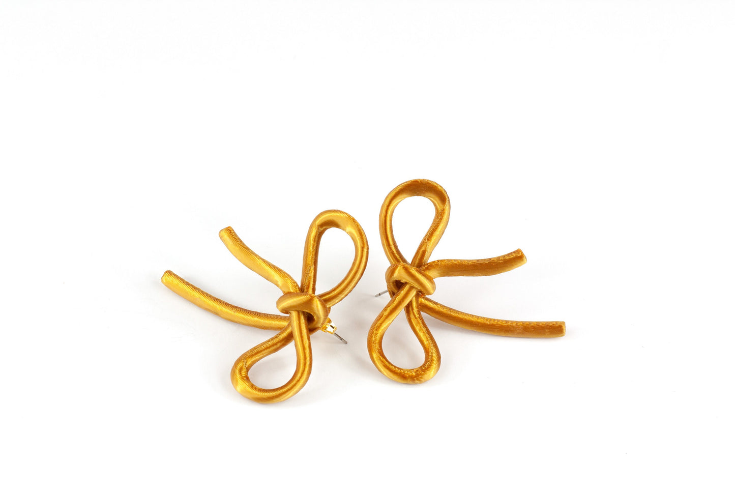 Bow-shaped earrings from the Coquette Collection, in gold silk finish.