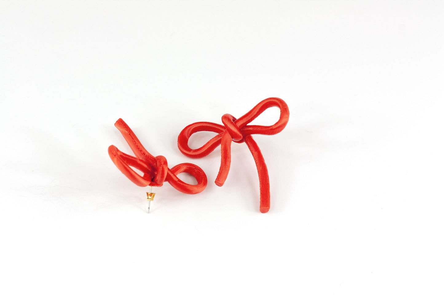 Bow-shaped earrings from the Coquette Collection, in red silk finish.