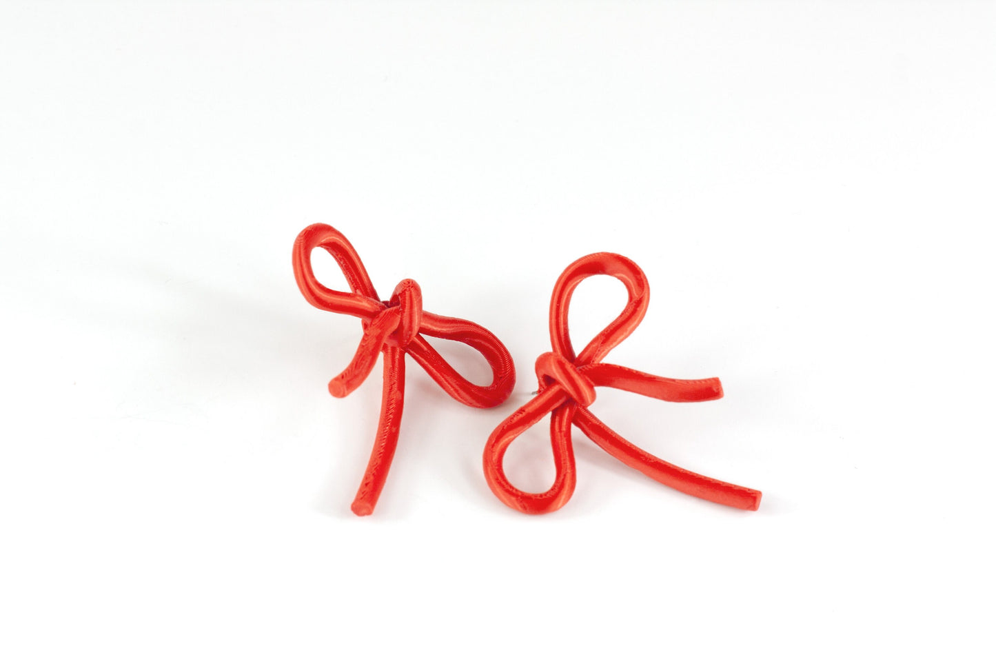 Bow-shaped earrings from the Coquette Collection, in red silk finish.