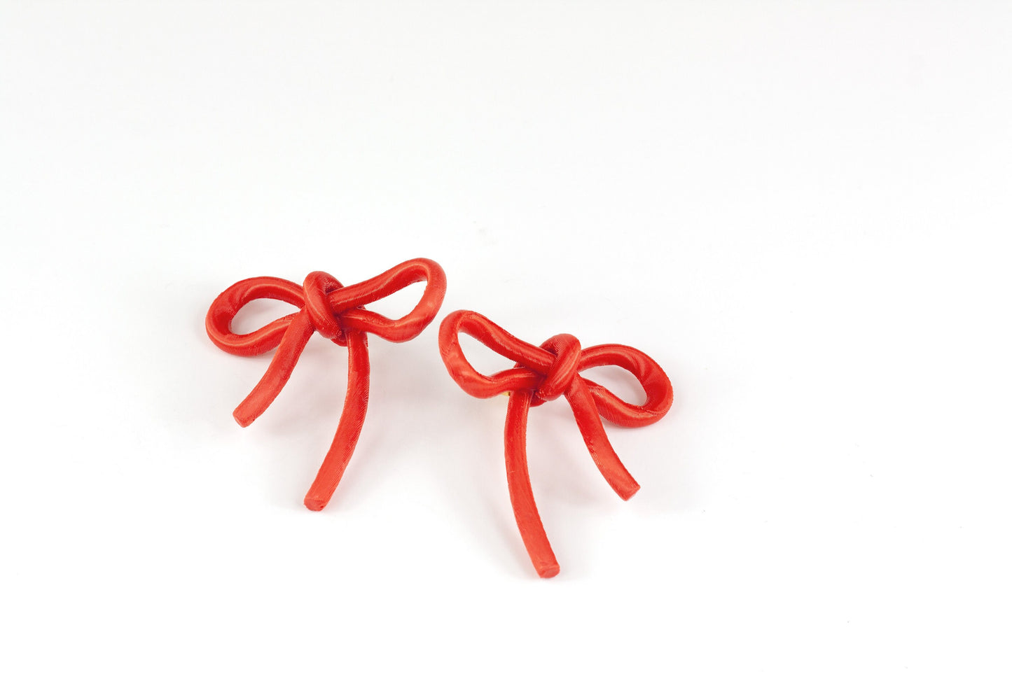 Bow-shaped earrings from the Coquette Collection, in red silk finish.