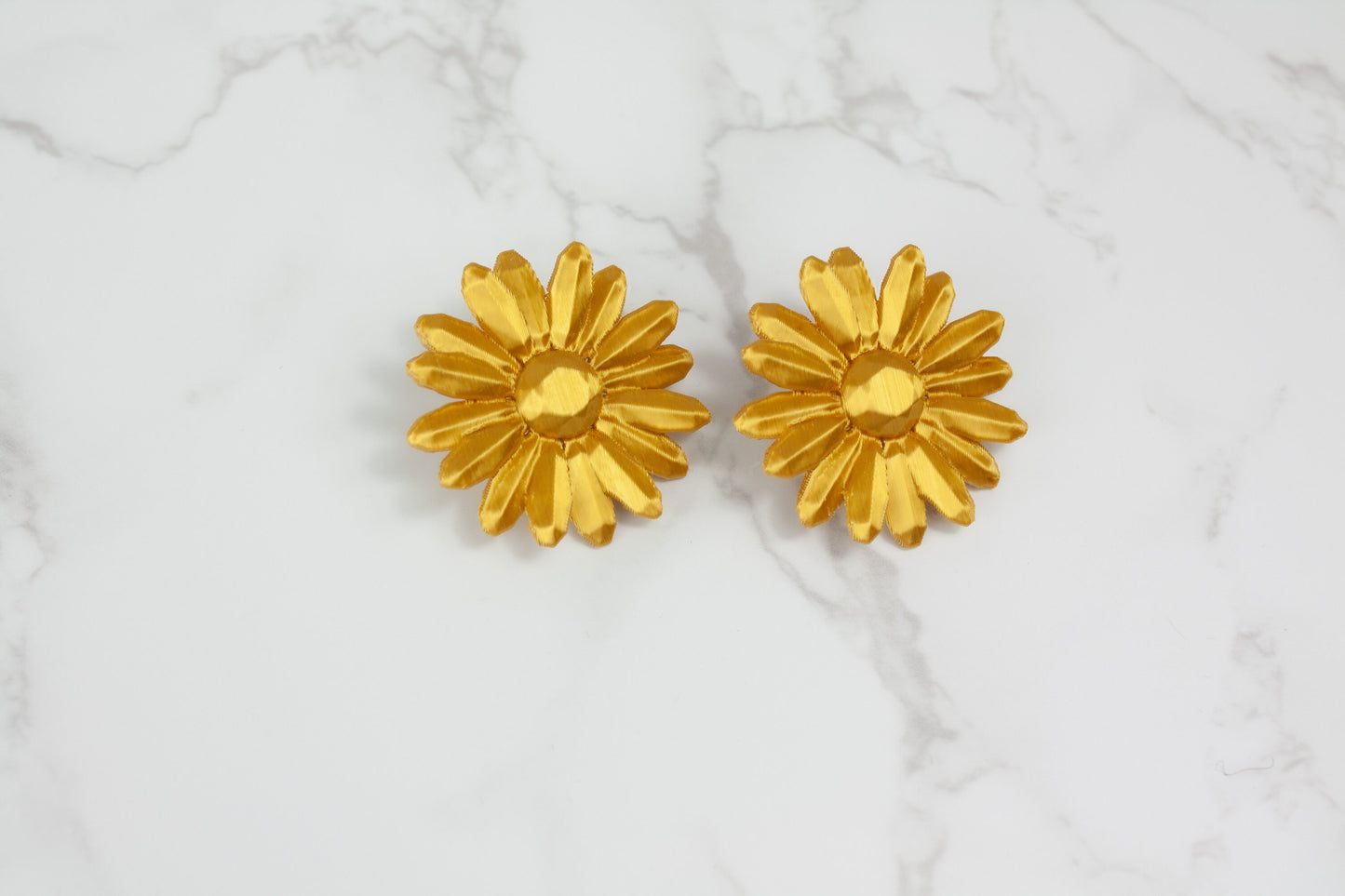 Marga stud earrings. In gold, they sit right next to your ear.