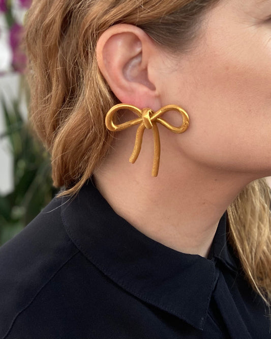 Bow-shaped earrings from the Coquette Collection, in gold silk finish.
