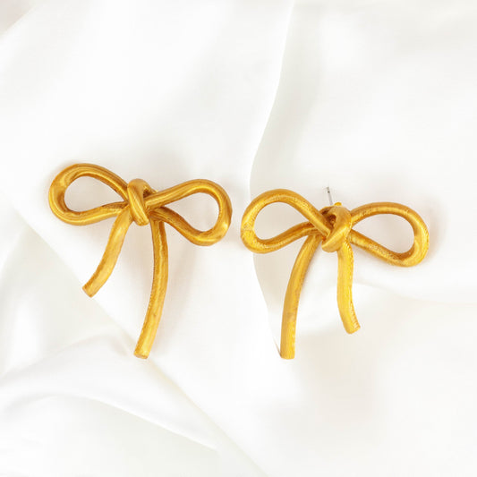 Bow-shaped earrings from the Coquette Collection, in gold silk finish.